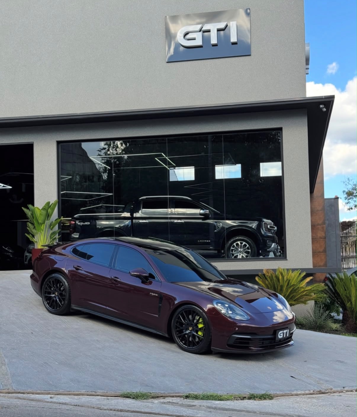 Showroom da GTI Automóveis em Tatuí/SP com Porsche Panamera na entrada